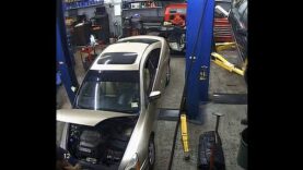 A mechanic gets his corners stuck in the hood of a car